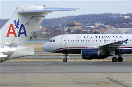 A US Airways plane taxis for takeoff past an American Airlines plane at the Ronald Reagan Washington National Airport in Virginia